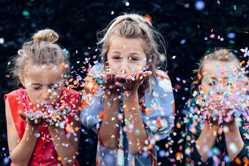 10th birthday ideas for girl: 3 girls blowing colorful confetti off their hands