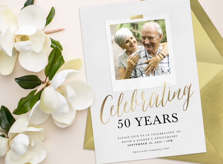 A 50th anniversary photo invitation with a gold envelope, surrounded by magnolias