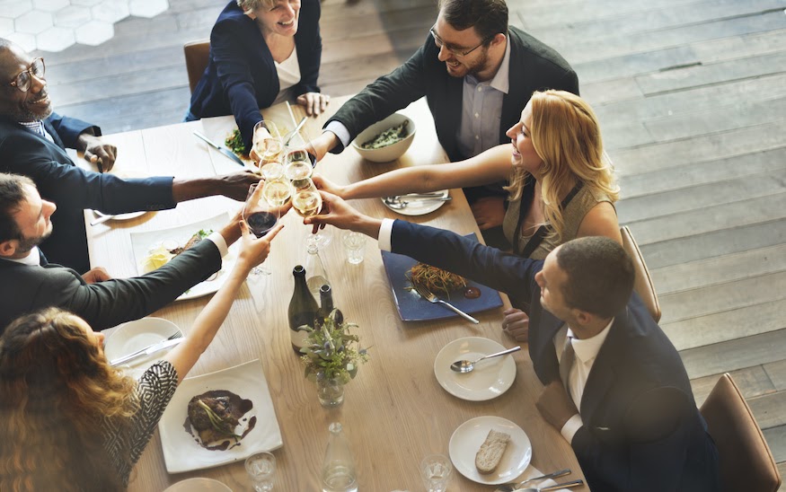 Corporate event planning: Team members cheers at a corporate dinner