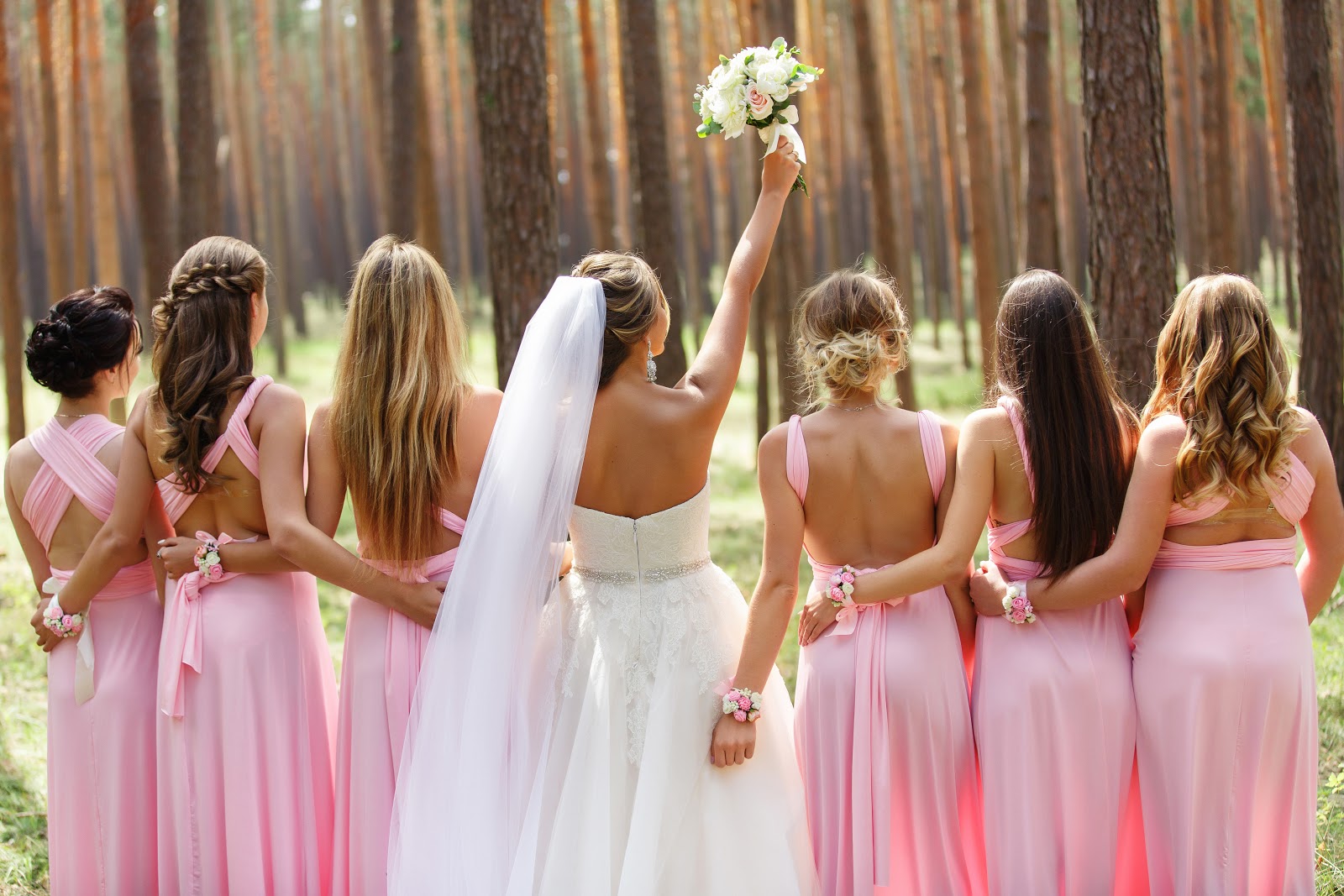 Bride with her bridesmaids in pink dresses during the wedding day