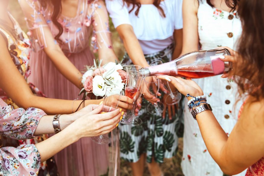 Bridal shower etiquette: A woman pours champagne into other women's glasses