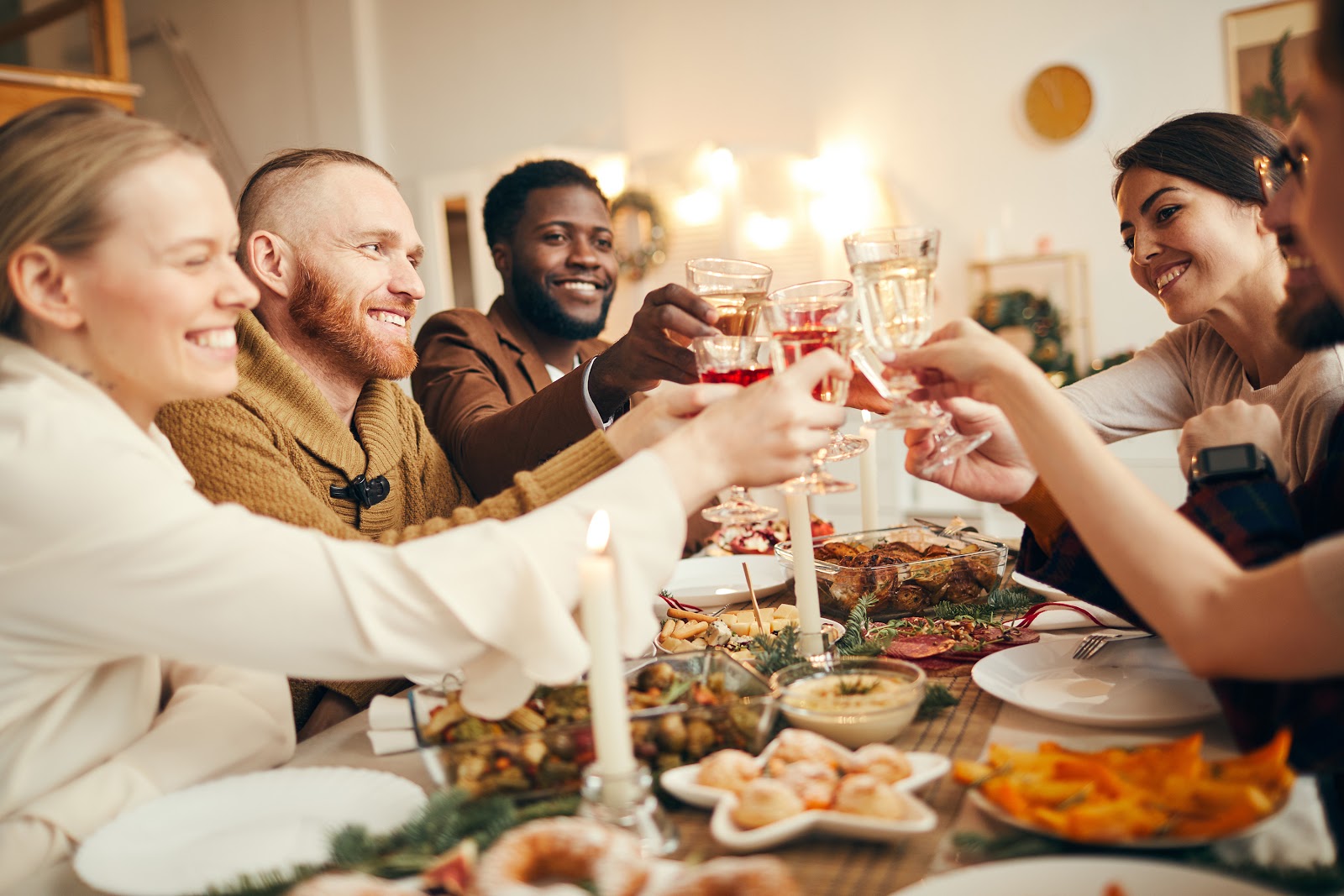 Non-traditional thanksgiving dinner ideas: An eclectic group of friends raise their glasses over the Thanksgiving table