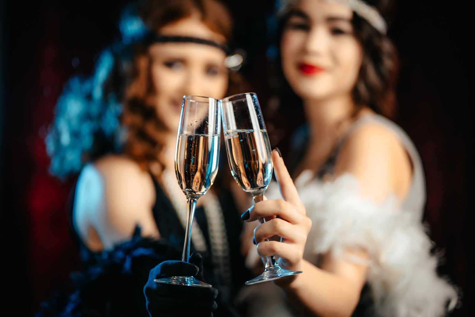 Two women holding champagne glasses in a Great Gatsby party