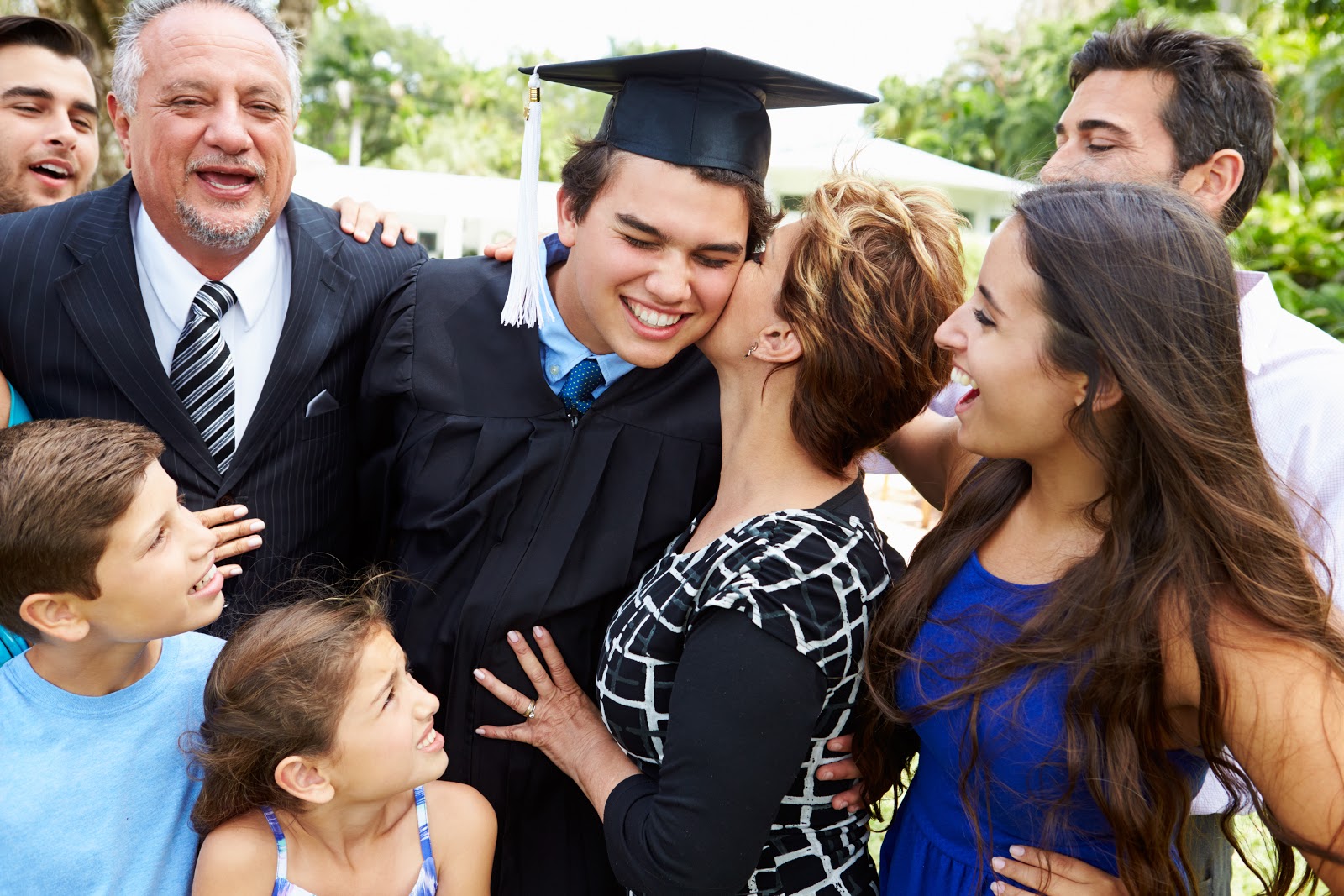 Mom kissing his son on graduation day