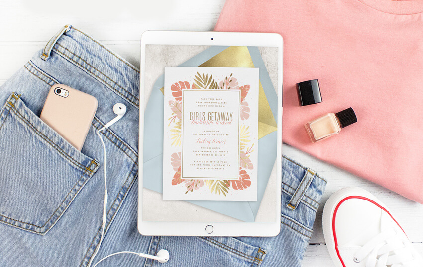 Girl's getaway weekend invitation displayed on an iPad with some femme clothing and nail polish nearby