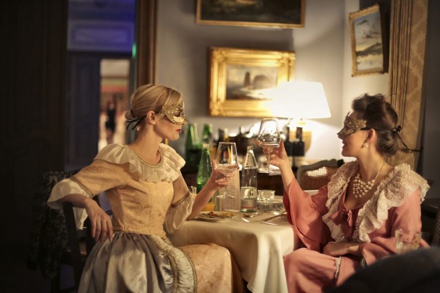 Two women at a masquerade murder mystery dinner party