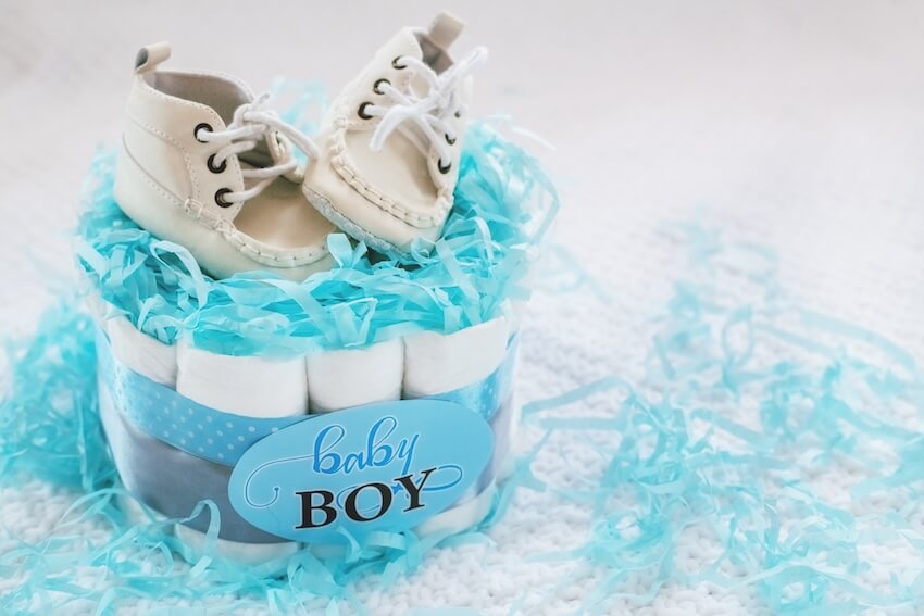 Baby shower ideas for boys: a pair of baby shoes on top of a diaper cake