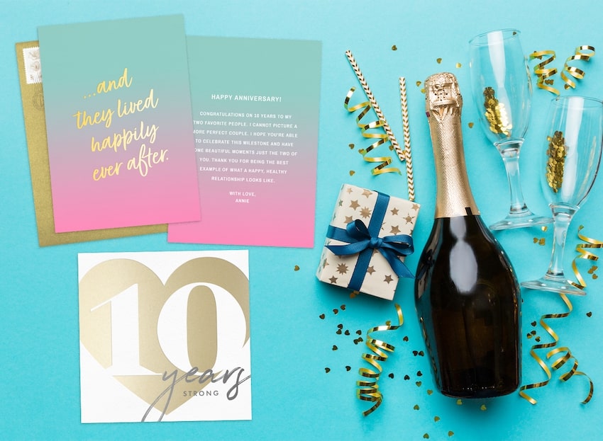 Wedding anniversary wishes: anniversary cards, a bottle of wine, and 2 champagne glasses