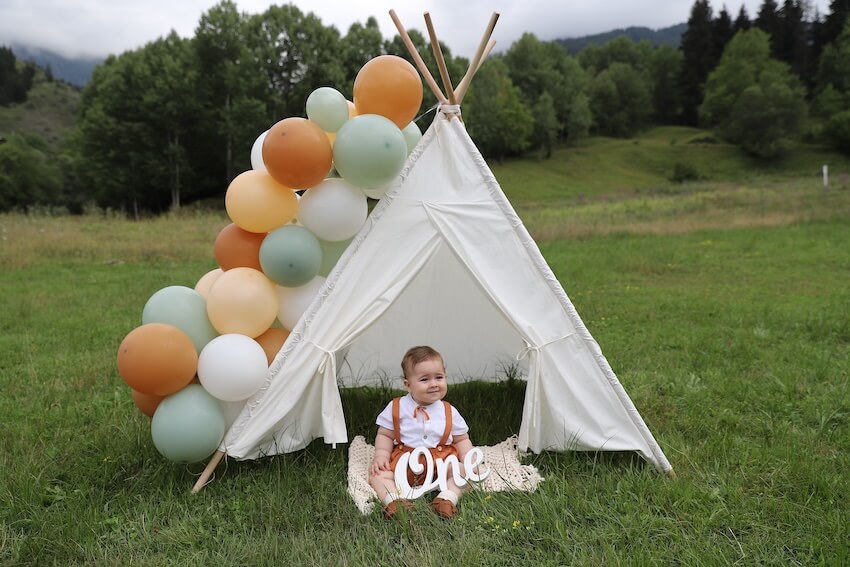 One happy camper birthday: baby boy having a photoshoot outdoors