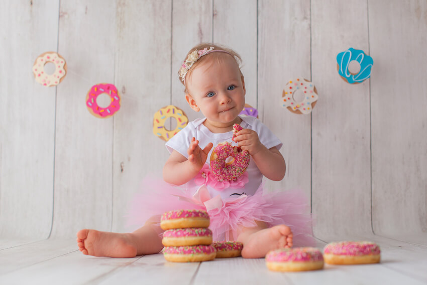Sweet one birthday: baby eating a donut