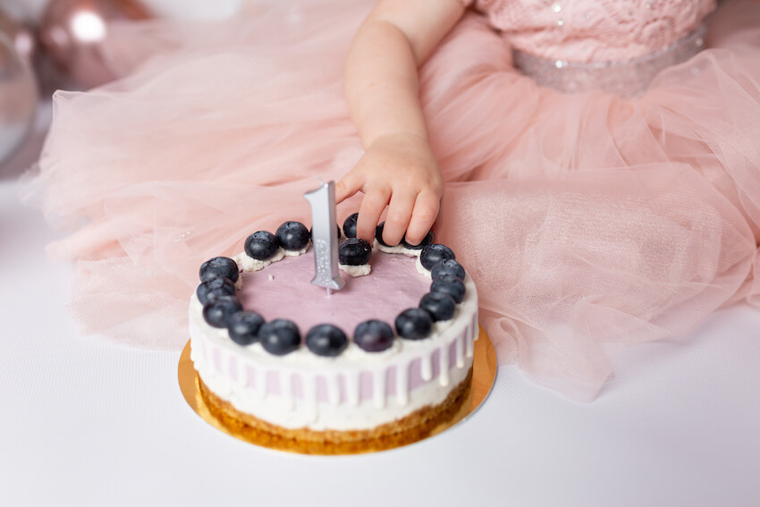 Berry first birthday: baby getting berries from her cake