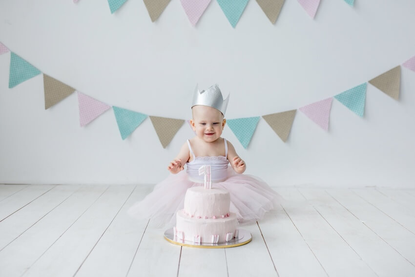 Fairy first birthday: baby girl looking at her cake