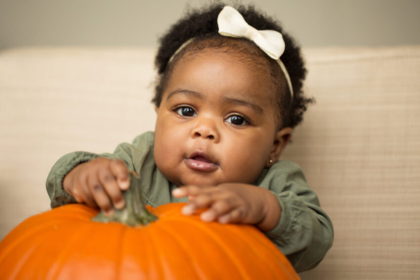 Pumpkin baby shower: baby holding a big pumpkin