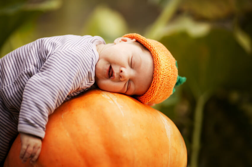Pumpkin baby shower: baby sleeping on a big pumpkin