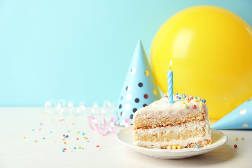 Balloon party hats and a slice of cake on a plate