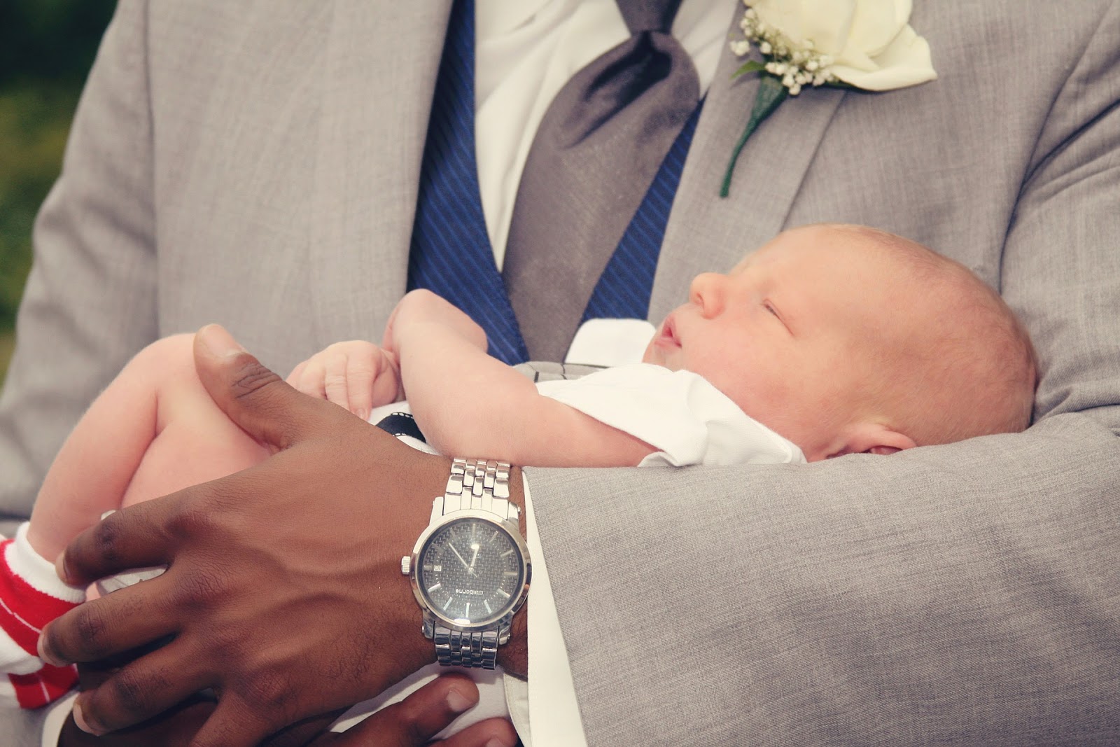 A man in a suit holds a baby