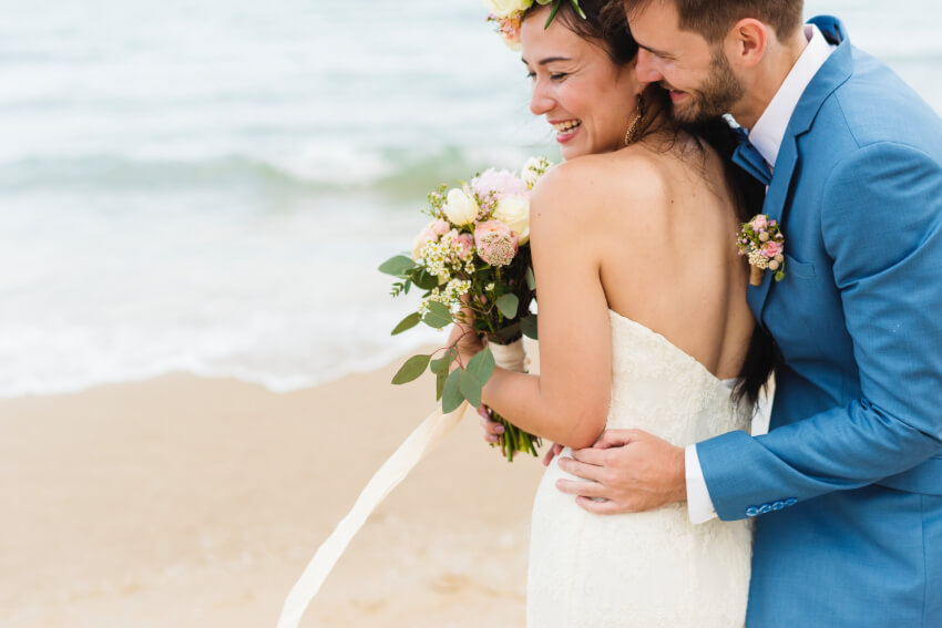 Beach wedding invitations: a smiling bride and groom on the beach