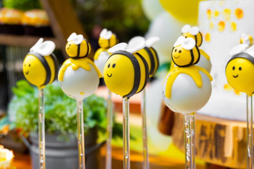 Neutral baby shower theme: bee themed candies on a stick