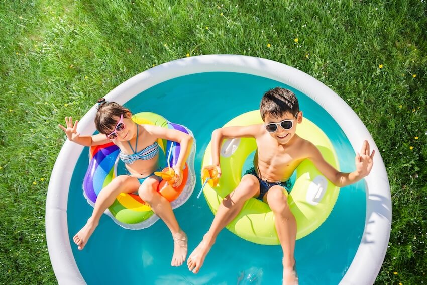 Boy and girl on floats in an inflatable pool