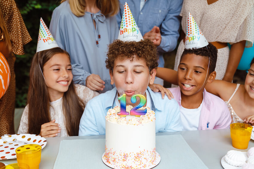 12 year old birthday party ideas: boy blowing out his birthday candles