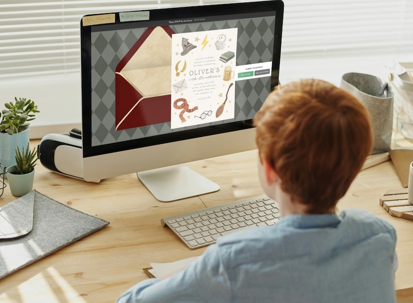11 year old birthday party ideas: boy looking at a birthday invitation on a computer screen