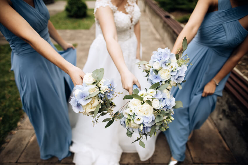 Bride and bridesmaids holding 3 bouquets