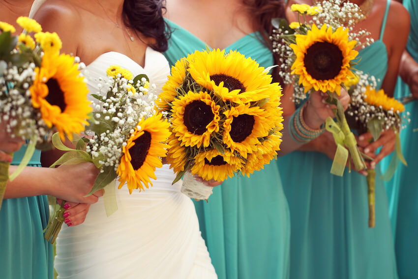 Sunflower wedding: bride and bridesmaids holding sunflower bouquets