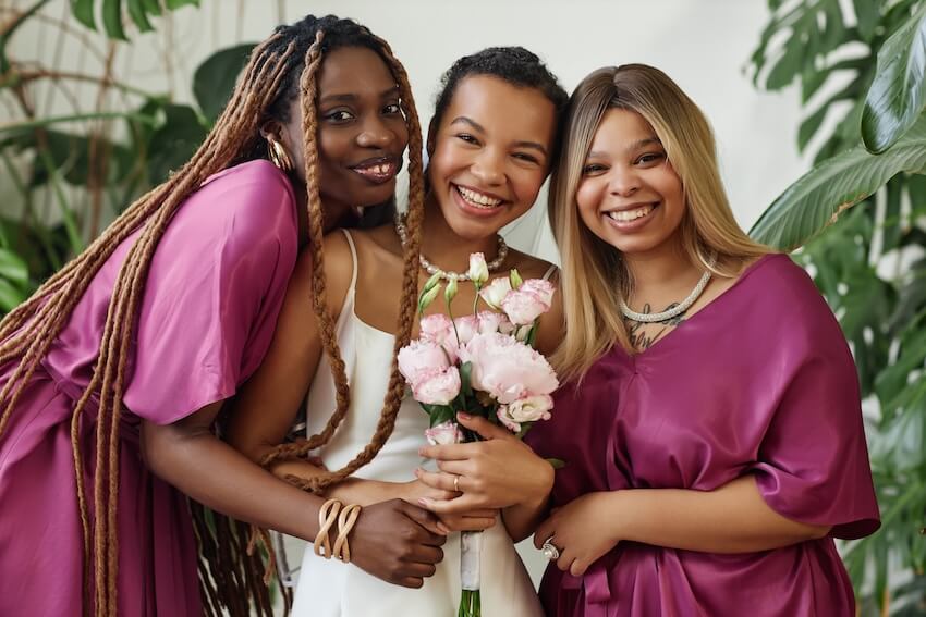 Bride and bridesmaids smiling at the camera