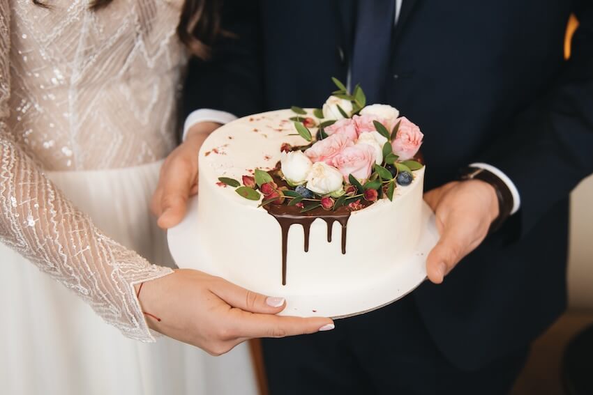 Bride and groom holding their wedding cake