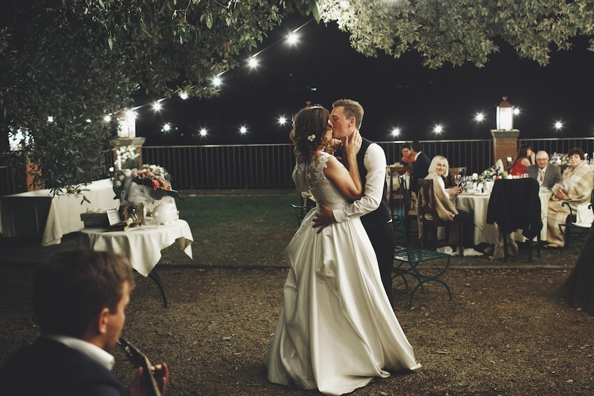 Backyard wedding: bride and groom kissing while dancing