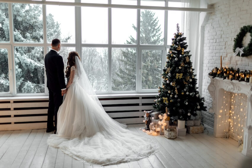 Winter wedding: bride and groom looking out the window