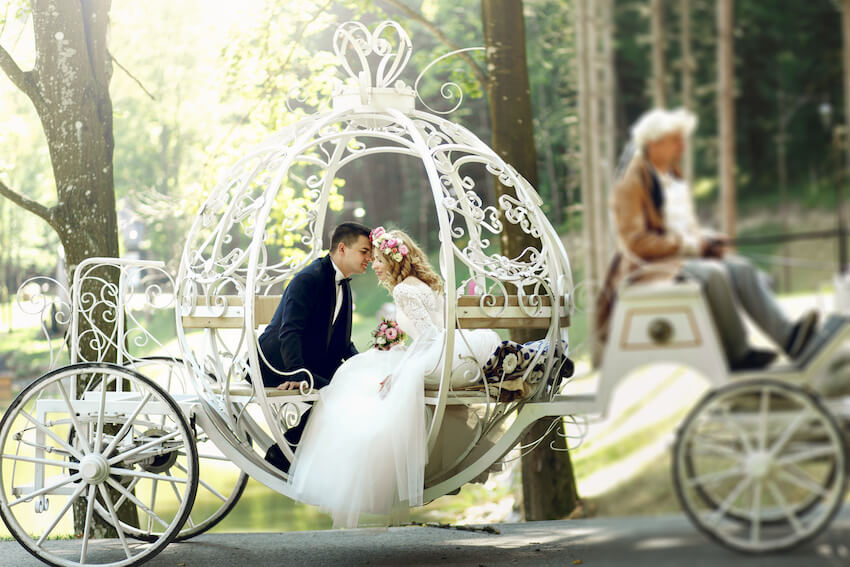 Fairytale wedding theme: bride and groom riding in a carriage