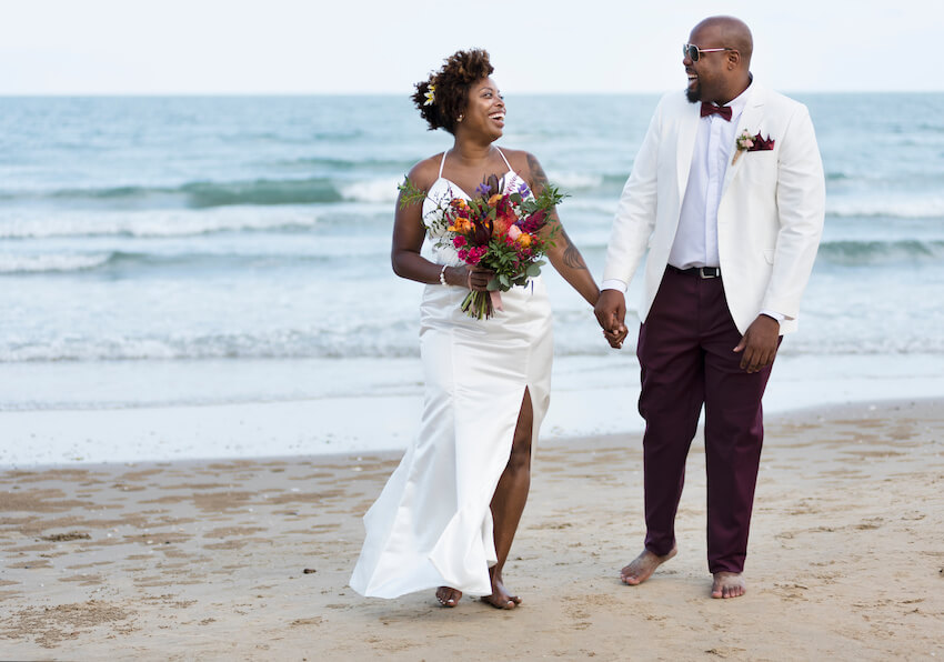 Beach wedding: bride and groom walking on a beach