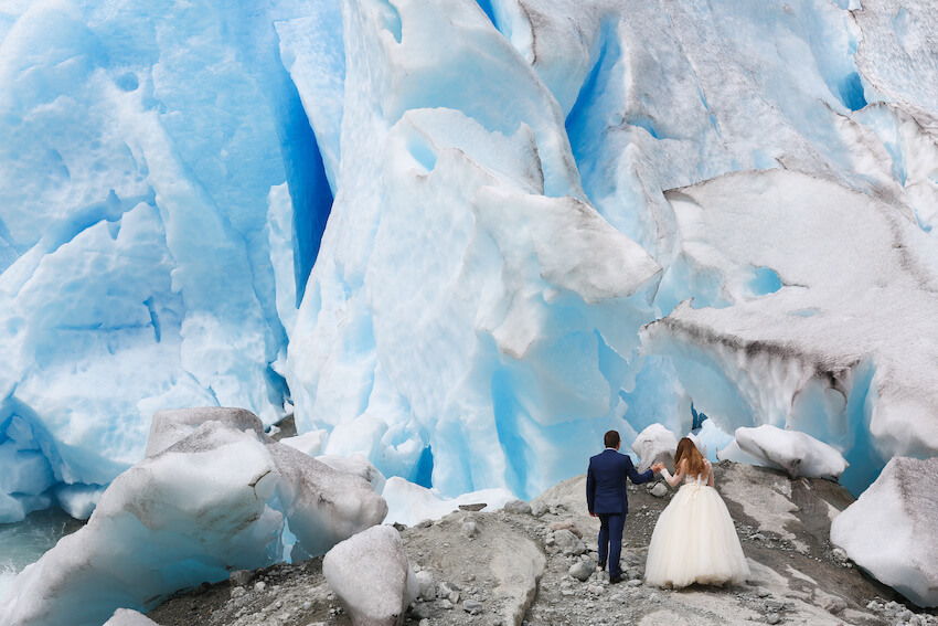National park wedding: bride and groom walking towards big glaciers