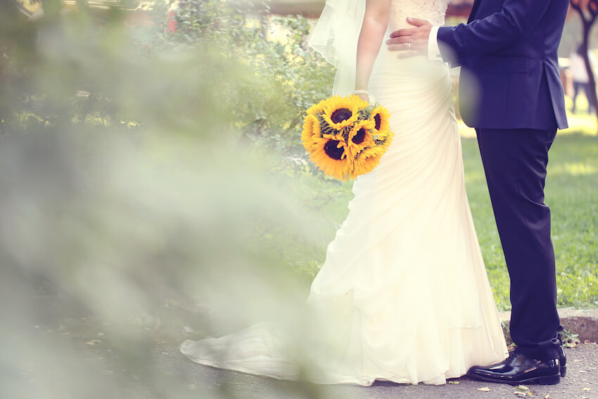 Sunflower wedding: bride holding a sunflower bouquet