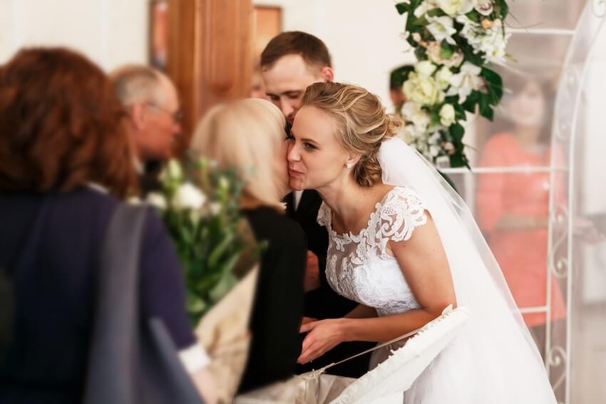 Wedding thank you: bride kissing her mom on the cheek