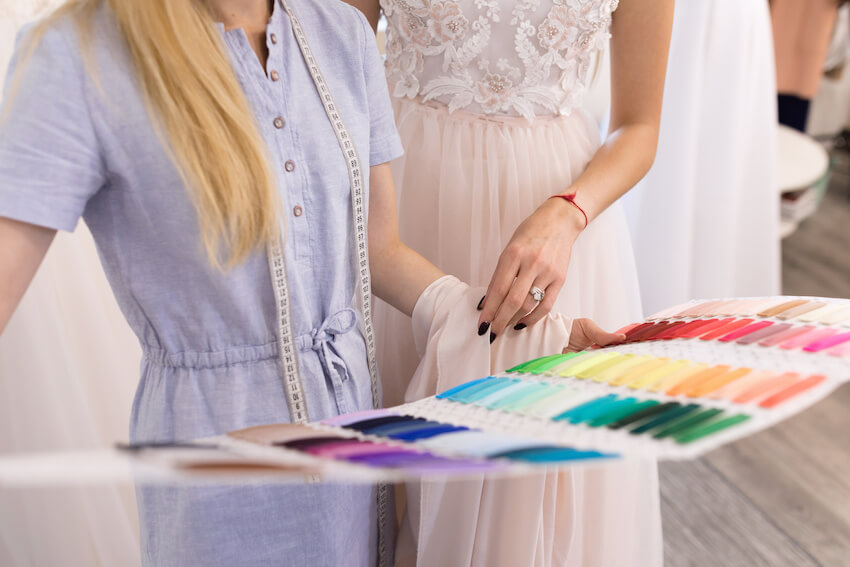 Best wedding colors: bride looking at fabric swatches