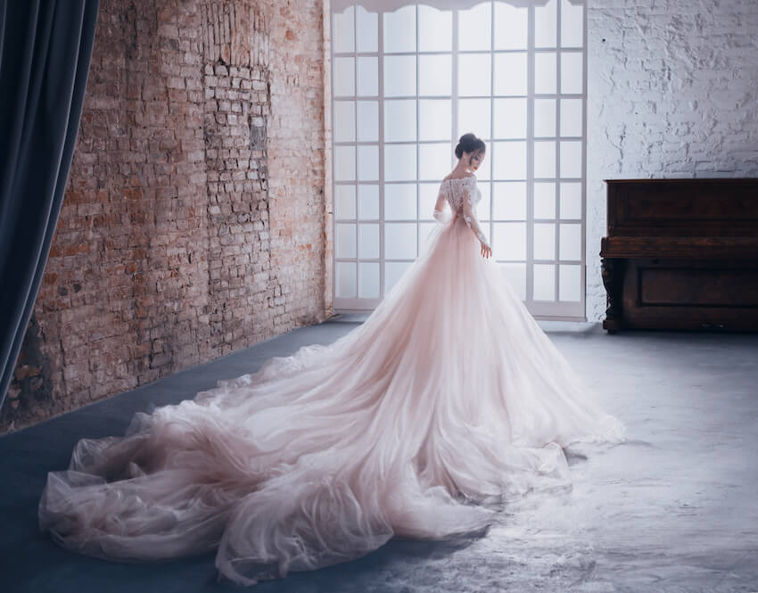 Fairytale wedding theme: bride wearing a gown with a long train