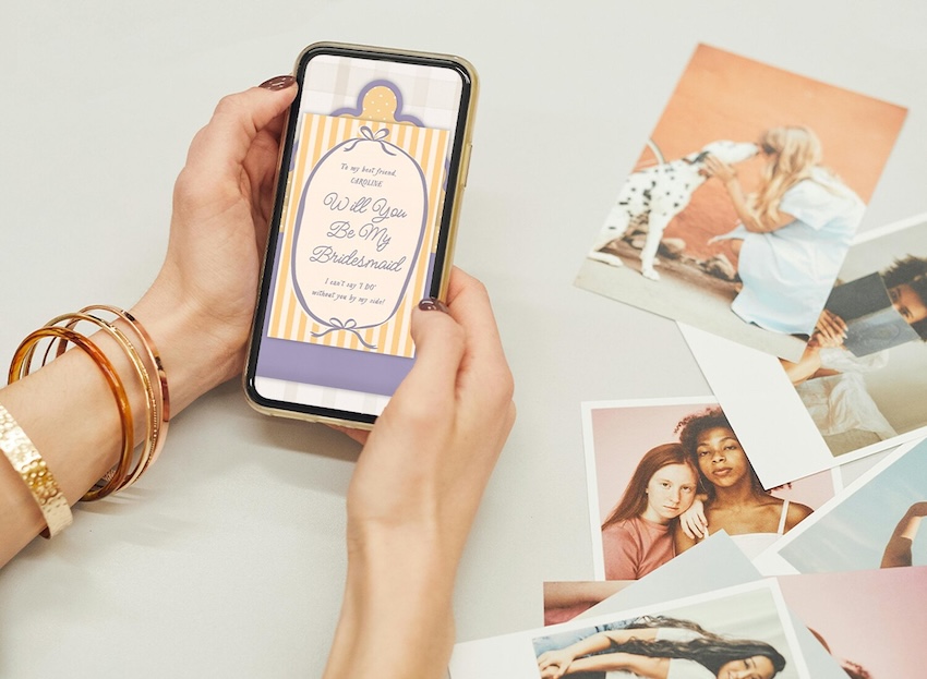 Bridesmaid invitation on a phone screen and printed photos beside it
