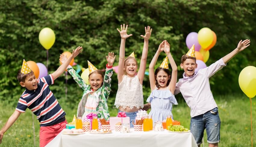 Children happily wearing party hats, posing for a picture