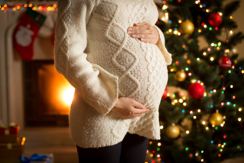 Winter pregnancy announcement: close up shot of a pregnant woman's belly