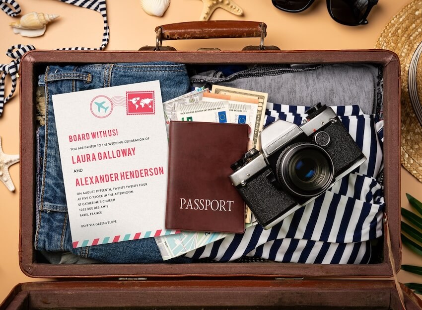Wedding invitations passport: clothes, a camera, and a passport in a suitcase