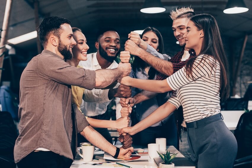 Community building activities: colleagues stacking their fists