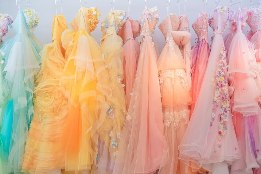 Non white wedding dresses: colorful wedding dresses hanging on a rack