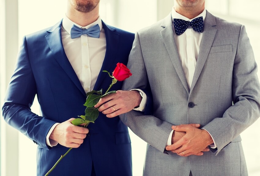 Wedding checklist: couple arm in arm while holding a rose