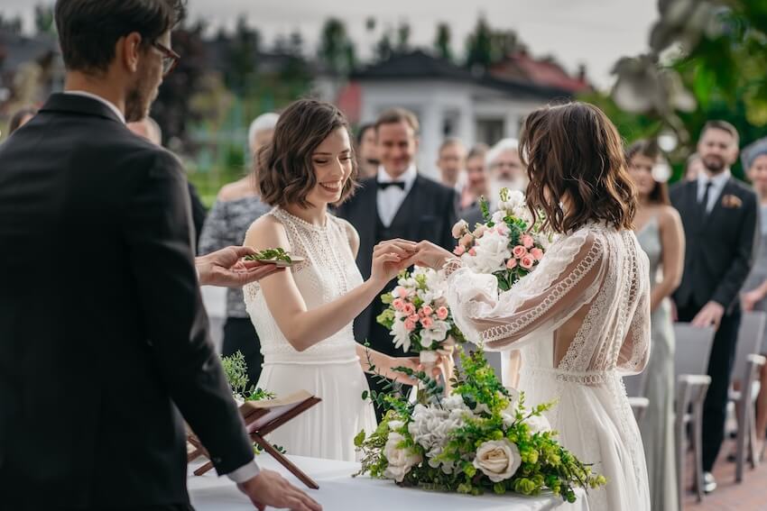 Wedding party roles: couple exchanging rings at their wedding