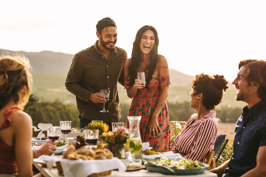 Couple happily drinking and eating with their family