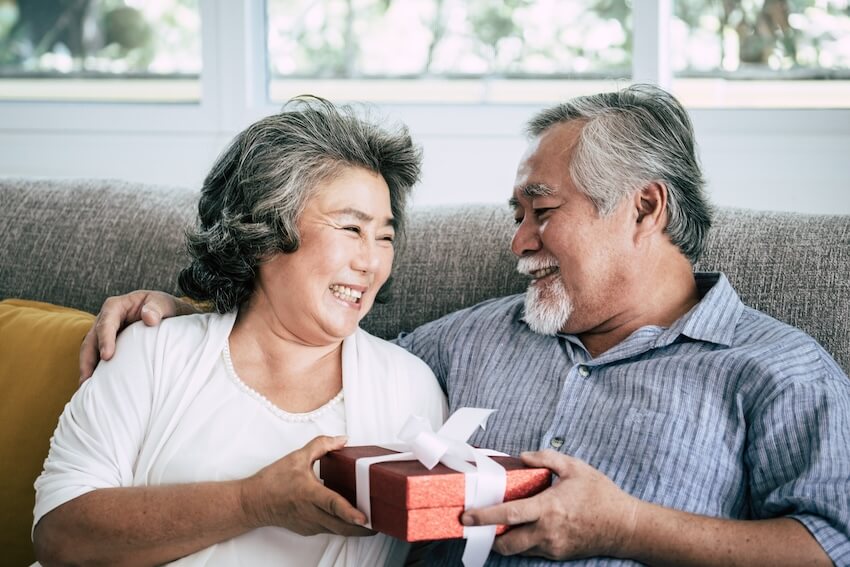 Anniversary themes by year: couple happily holding a gift box