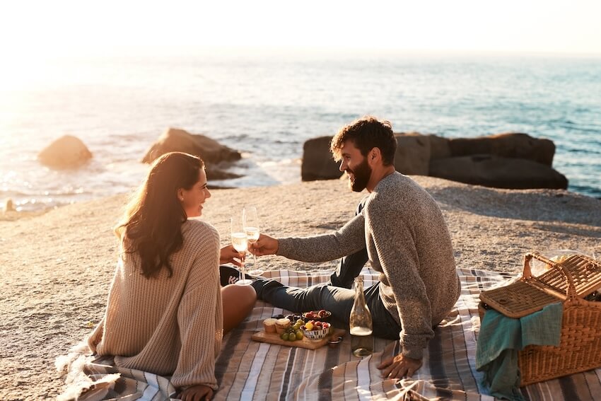 10 year anniversary ideas: couple having a picnic at a beach