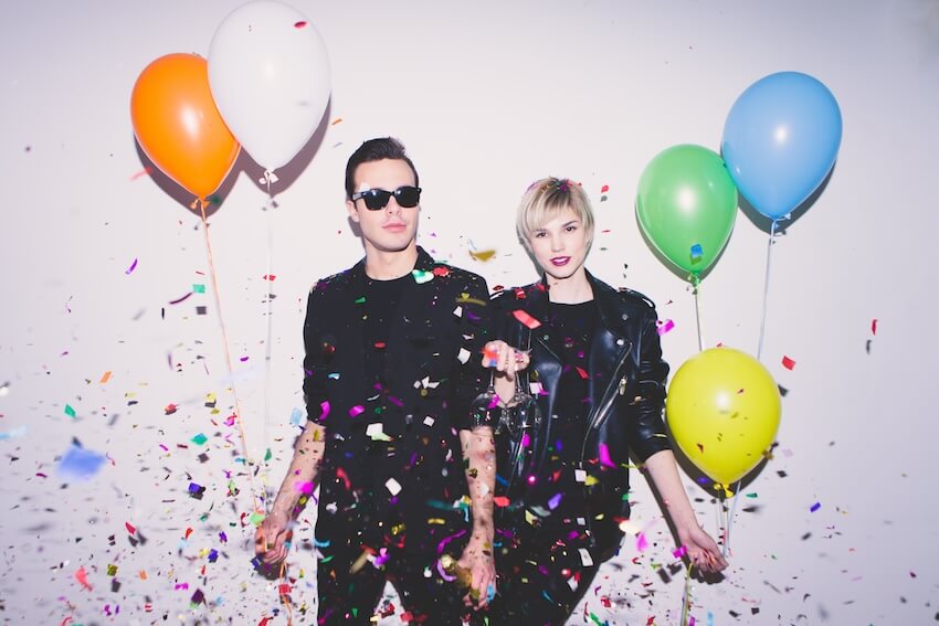 Happy birthday brother in law: couple holding balloons while posing at the camera